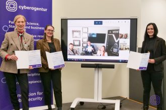 Vertragsunterzeichnung zwischen Cyberagentur und Ventel LLC: Bettina Bubnys, Ariane Wolf und Dr. Nicole Hartlapp präsentieren die unterzeichneten Dokumente, während Dr. C. Jordan Howell digital zugeschaltet ist.